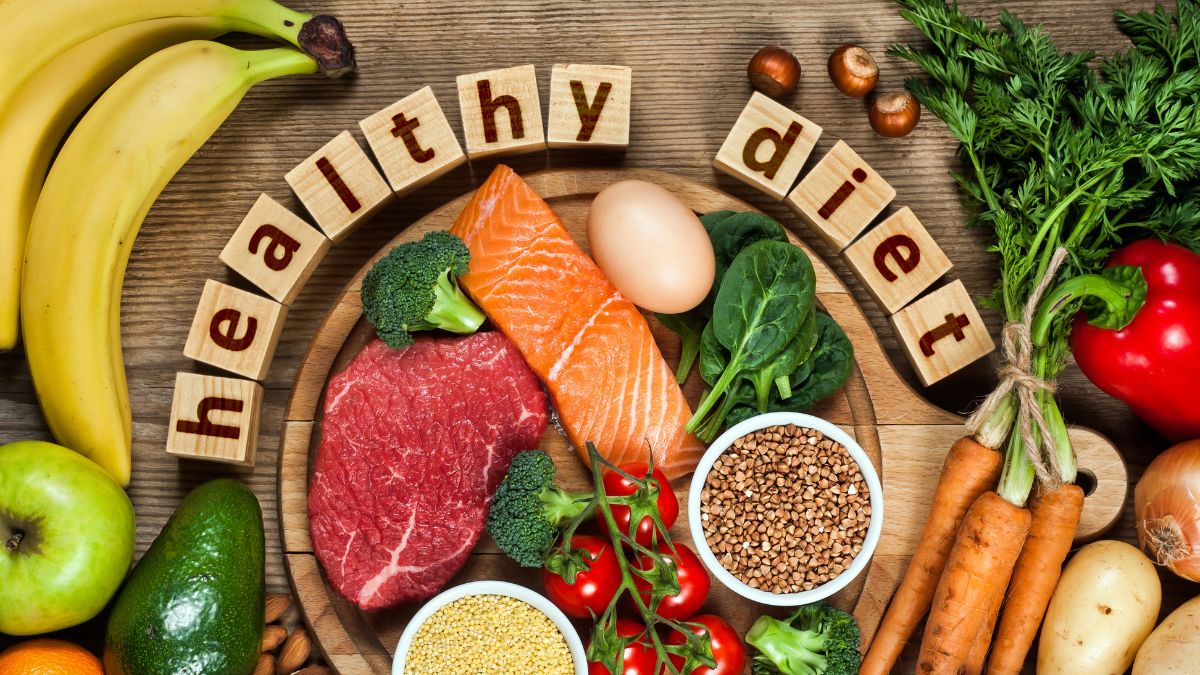  A wooden table with a variety of food items, including fruits, vegetables, grains, proteins, and dairy, arranged around a wooden block circle that reads 'Healthy Diet'.