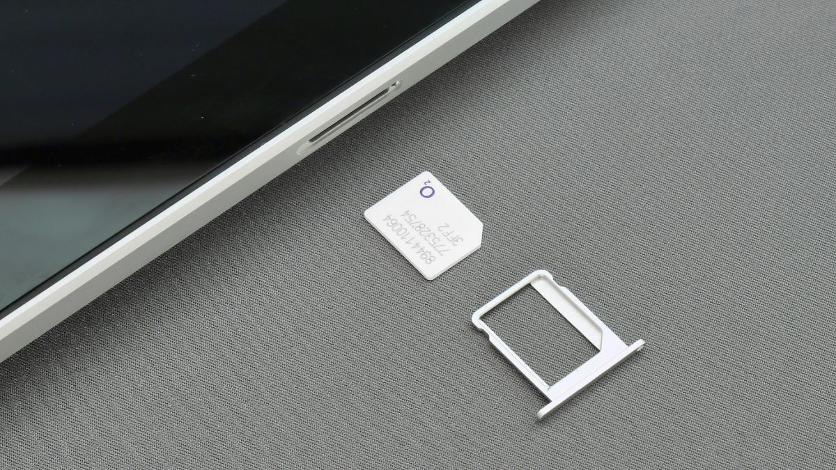  A SIM card lies next to a smartphone. The image represents the search query 'Risks of using apps to detect blocked phone numbers'.