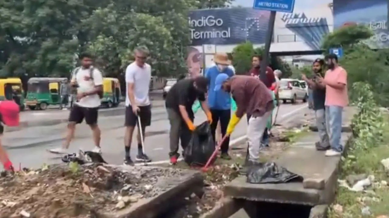 foreigners-living-in-gurgaon-clean-roads-and-drains-viral-video-sparks-backlash-as-netizens-call-it-shameful