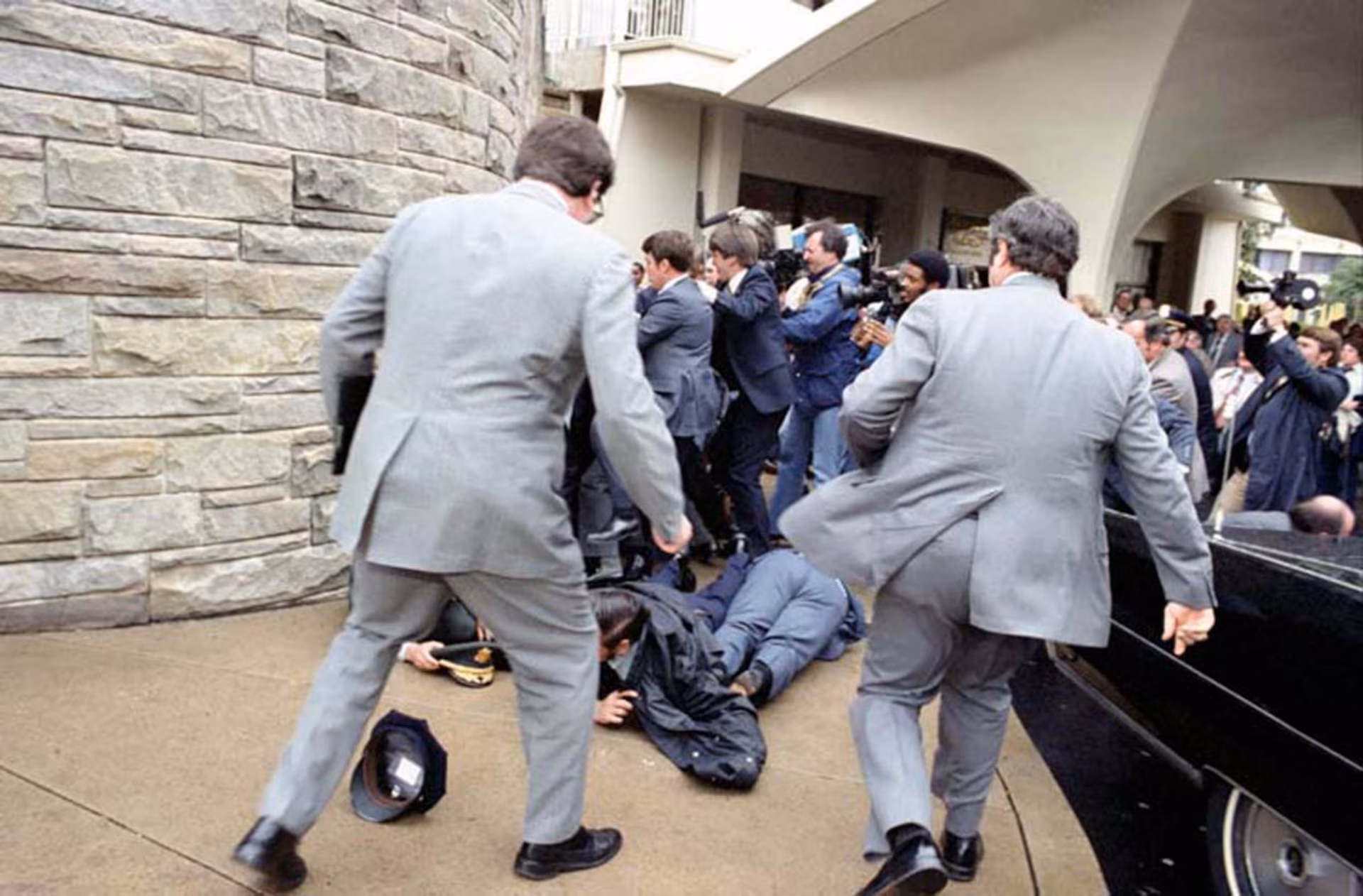 White House Press Secretary James Brady and District of Columbia police officer Thomas Delahanty lie wounded on the ground after John Hinckley Jr. fired six shots at President Reagan.